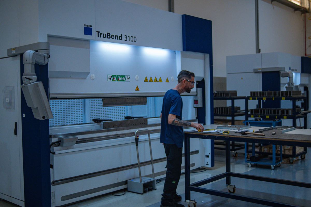Operador posicionando peça na dobradeira CNC TruBend 3100